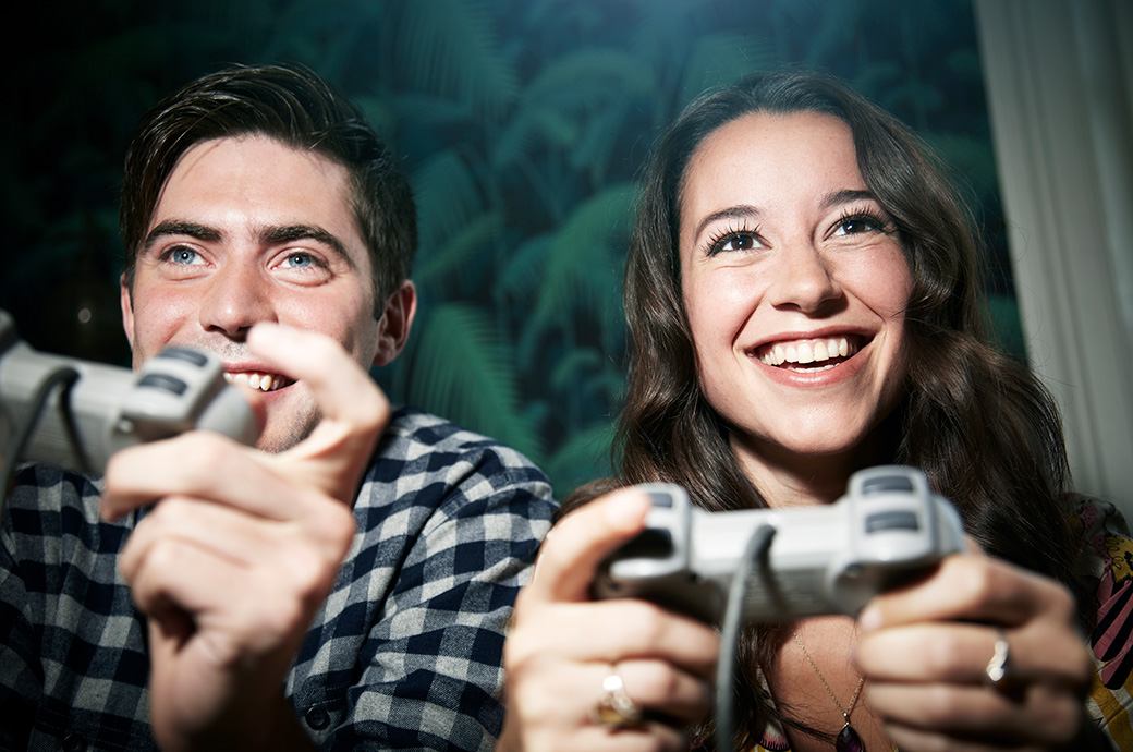 Two adults holding controllers playing video games